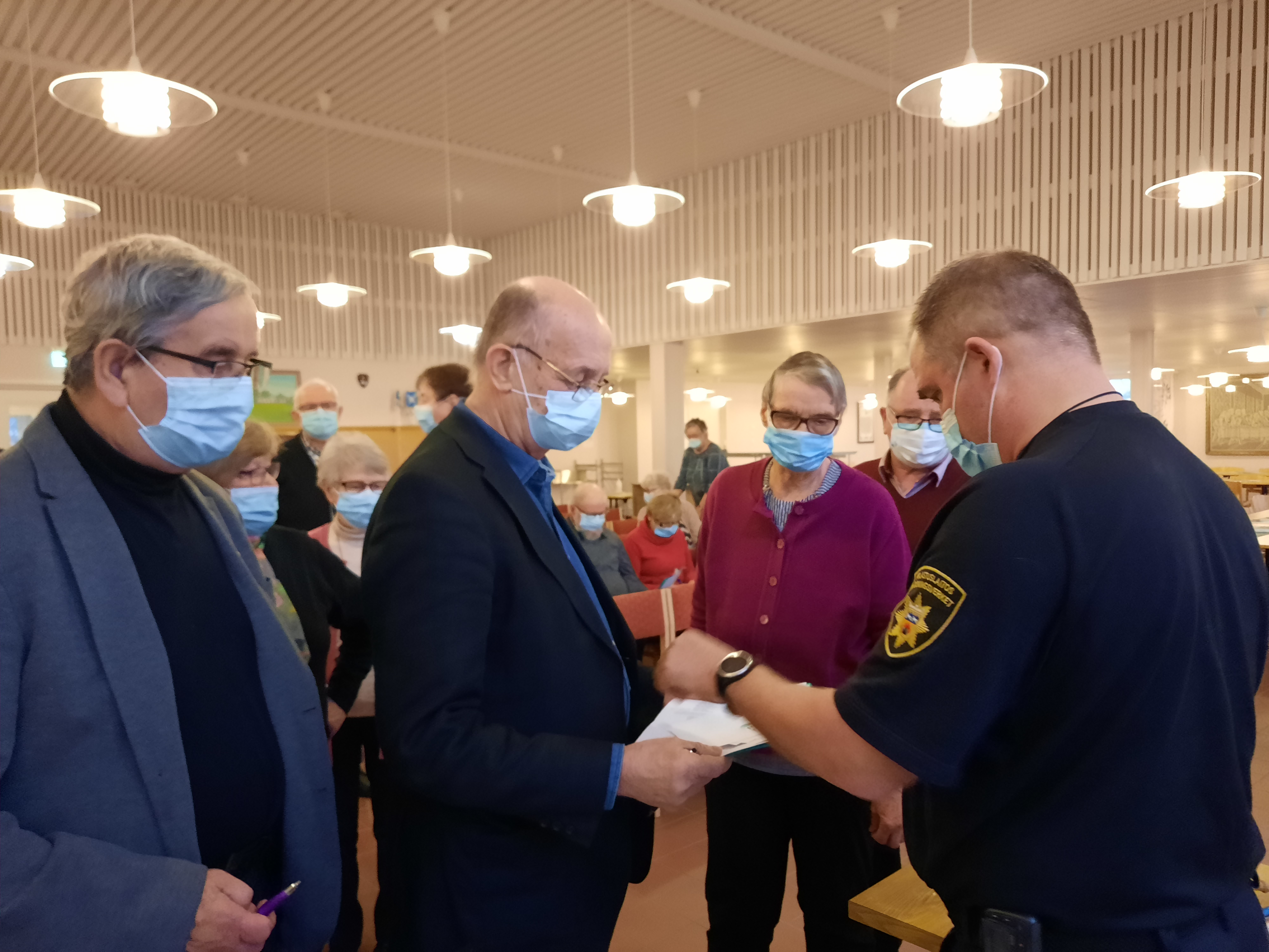 Ihmisiä kokouksessa kasvomaskeissa
