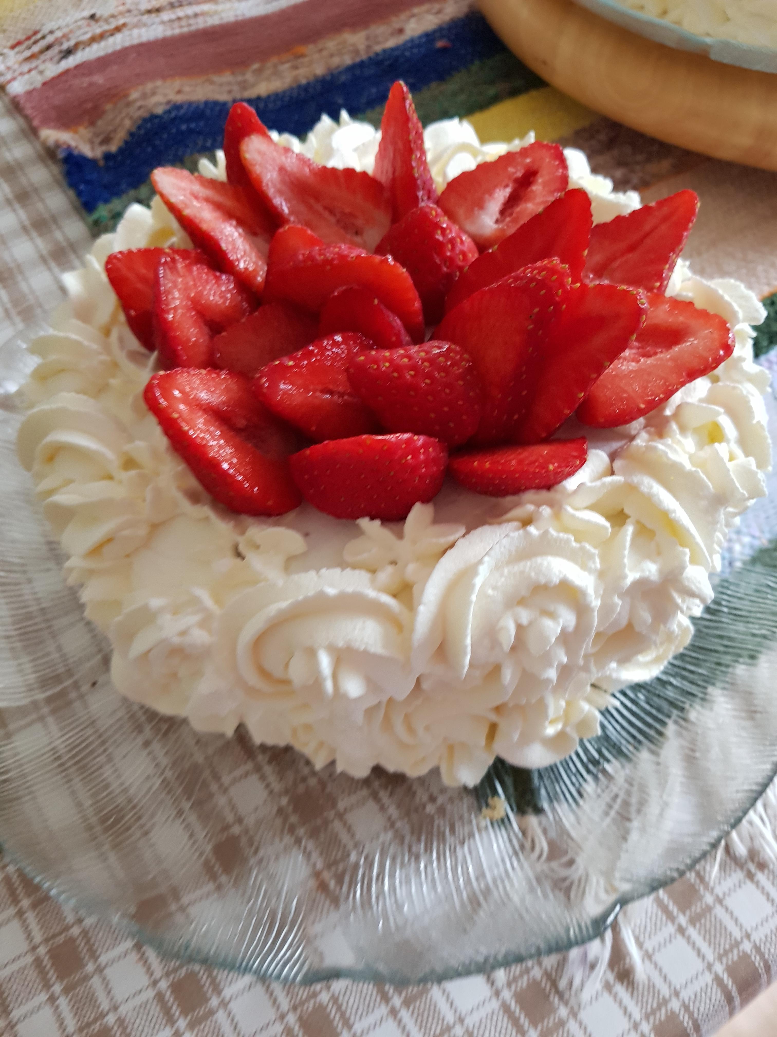 Kermakakku, jossa punaisia mansikoita päällä