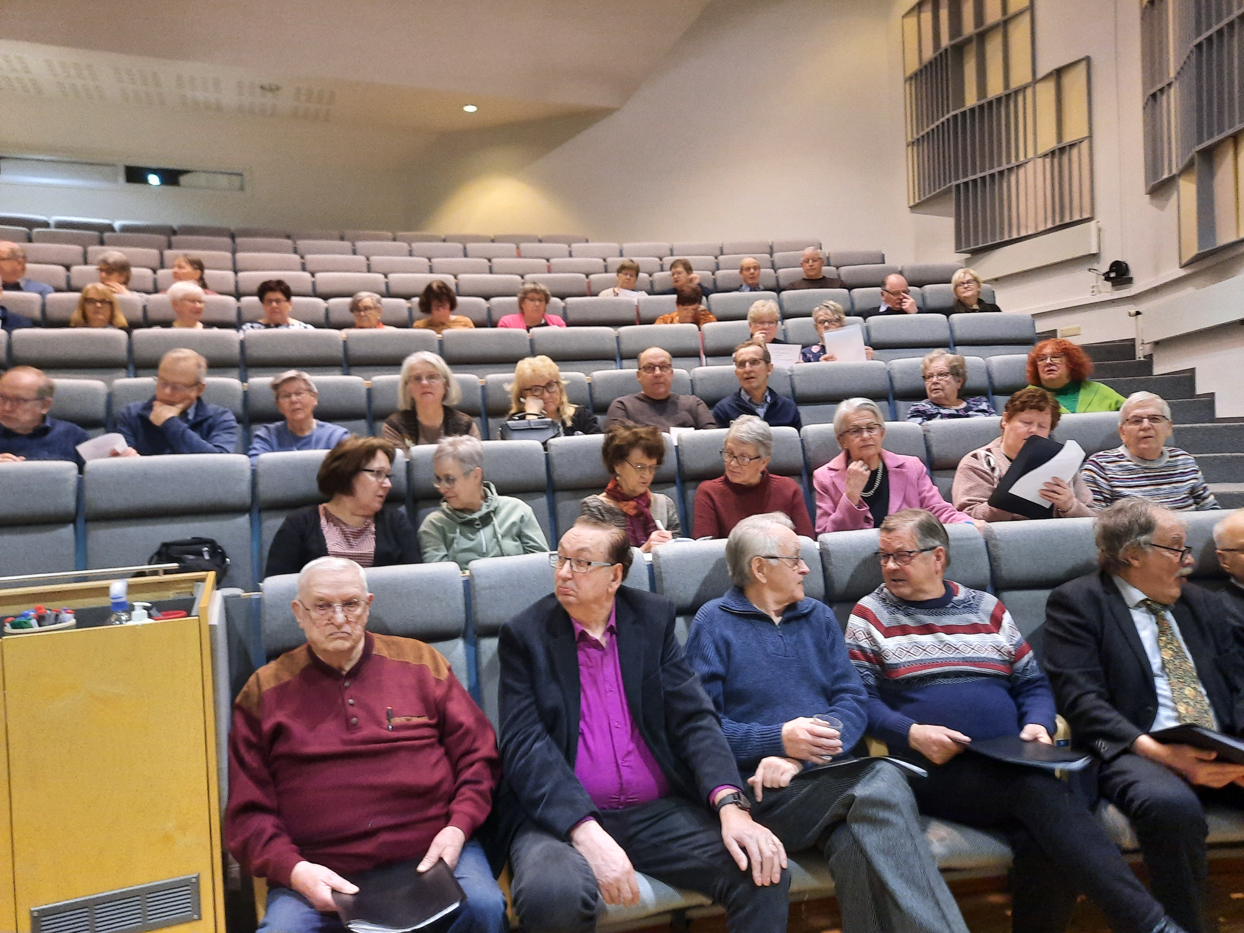 Ihmisiä auditoriossa