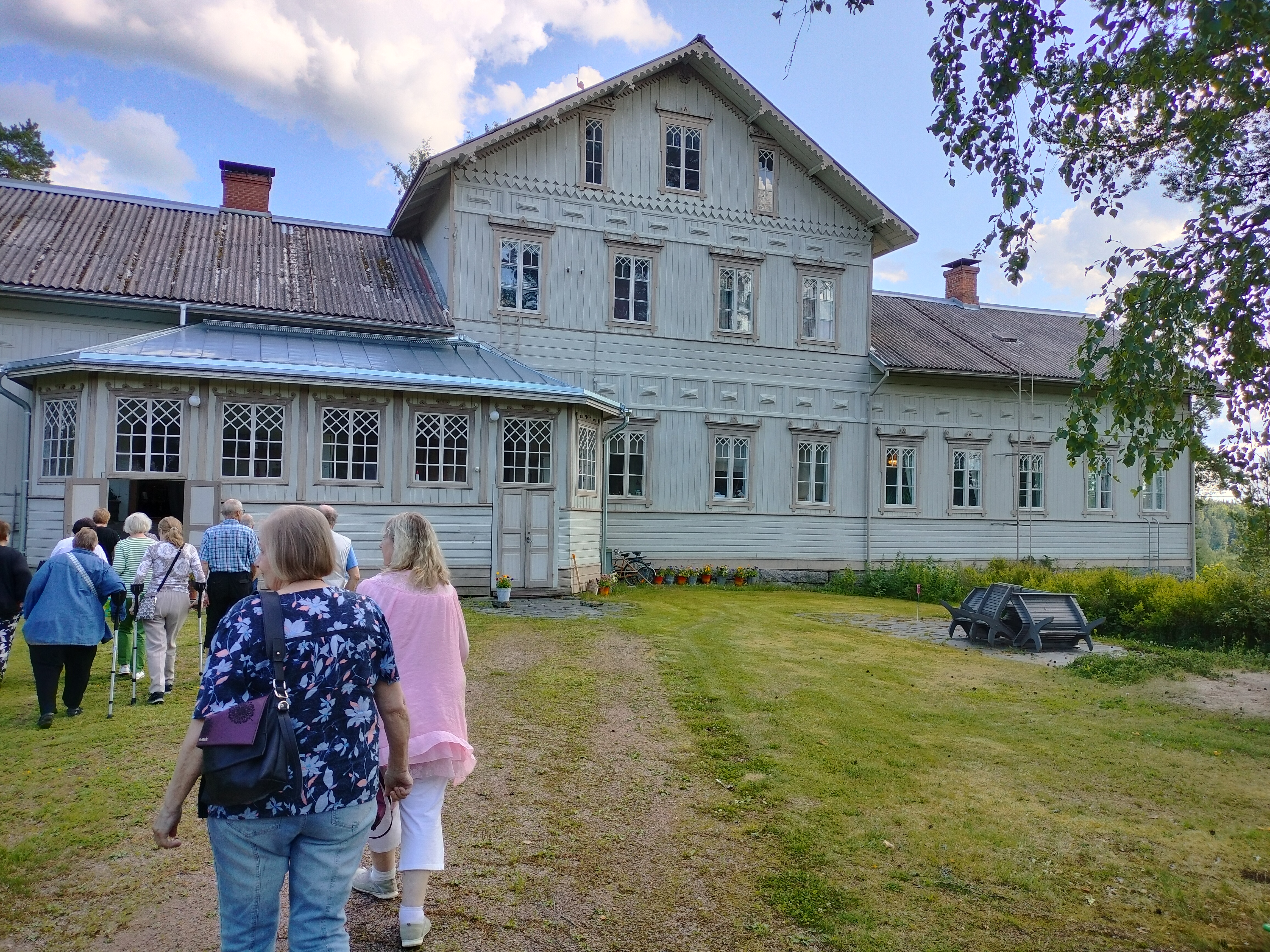 Ihmisiä vanhan talon luona