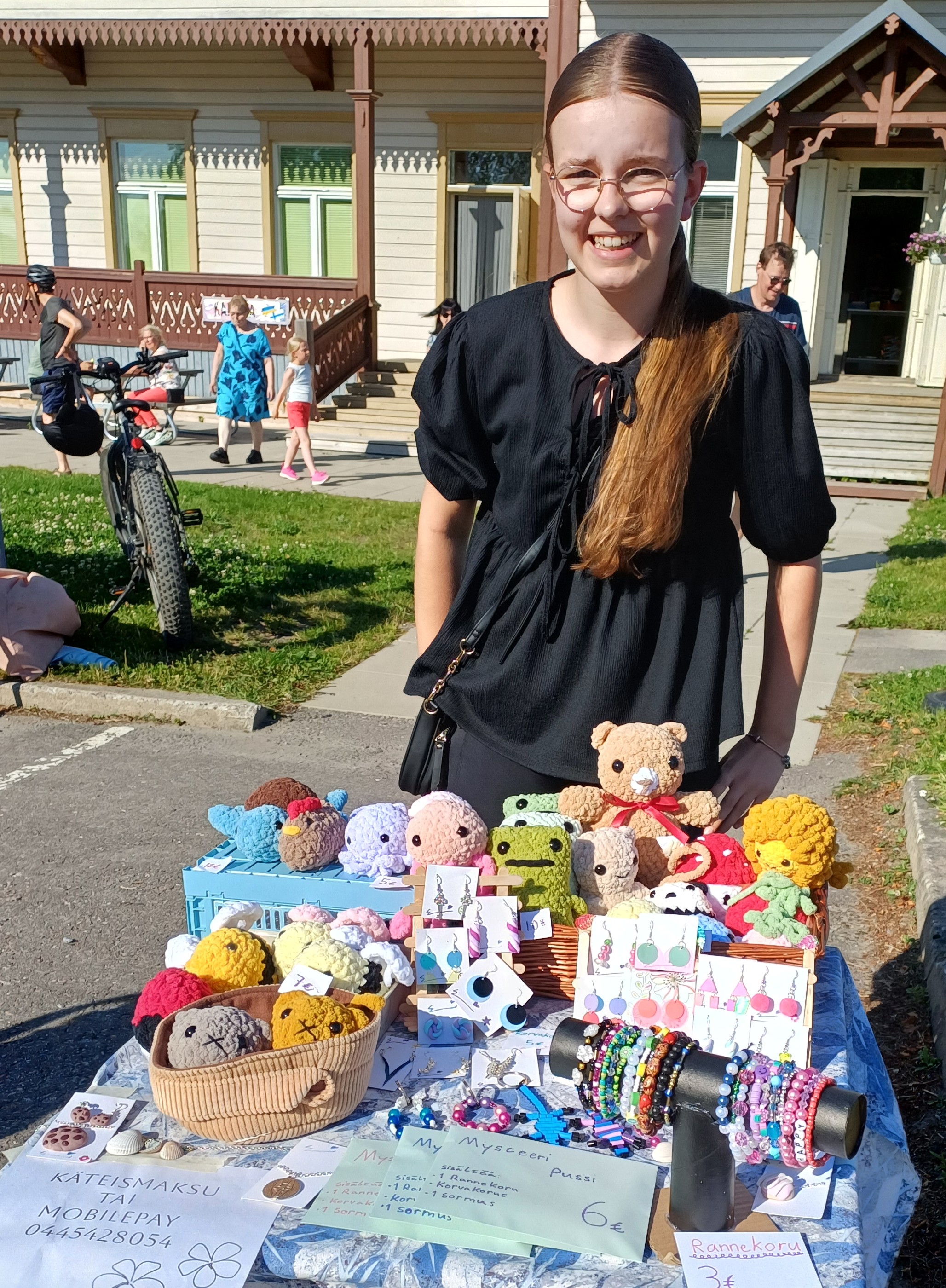 Iloinen koru-tyttö ja itse valmistamansa tuotteet