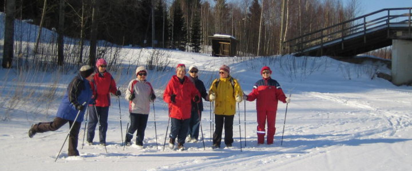 Naiset sauvakävelyllä lumihangessa