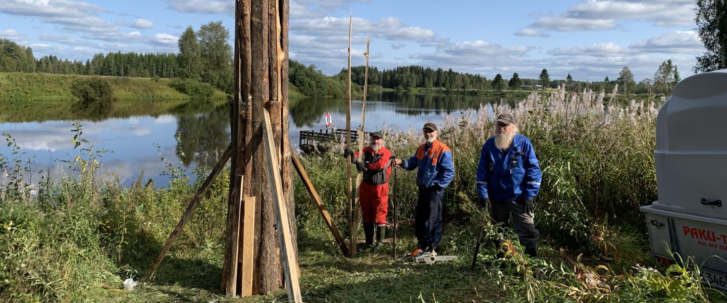 miehet kasaamassa kokkoa