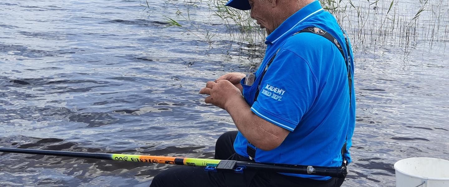 Onkimies laittaa matoa koukkuun