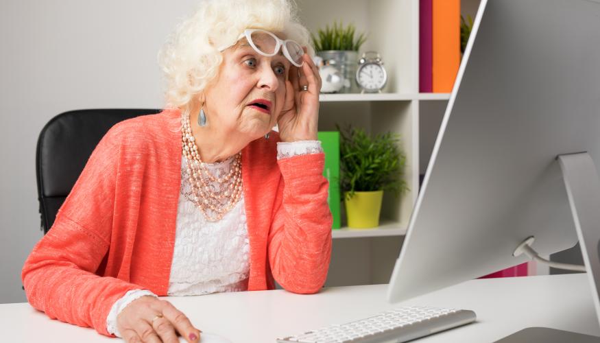 Vanha nainen katsoo tietokoneen näyttöä